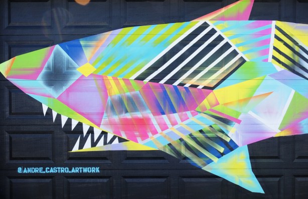 finished mural of a multicoloured whale on black background