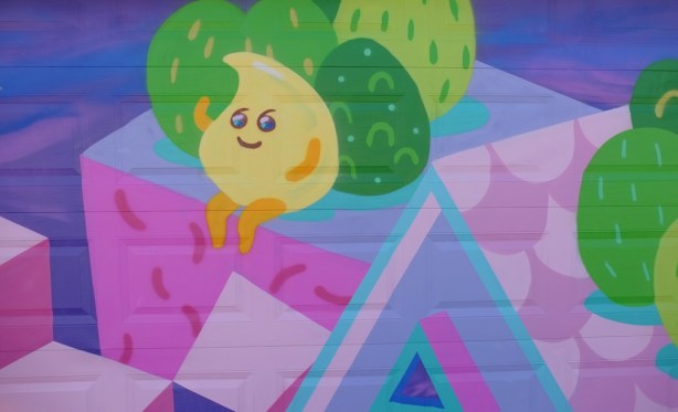 lemon drop character on a pink and purple house with green trees, a mural by Jieun June Kim