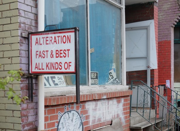 sign on an old house, now a commercial property, that says Alteration Fast & Best All Kinds Of 
