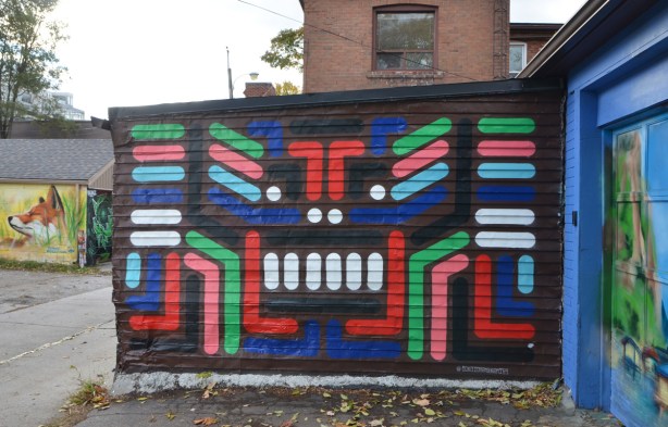 bars, dots, and stripes of colour on a black background, mural in a lane