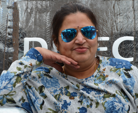a woman in blue sunglasses poses 