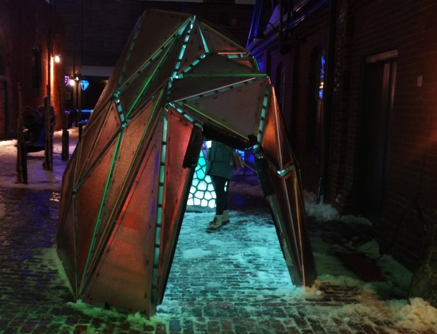 light art installation at Distillery District, like a small tent or hut that you can go inside, tiny triangle of colour, by artist Taylor Dean Harrison, looks like stained glass 