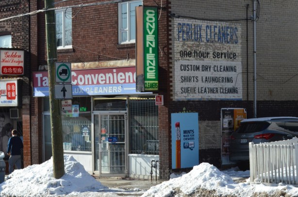 Perlux cleaners, old sign painted on side of building, convenience store, mounds of snow by the sidewalk