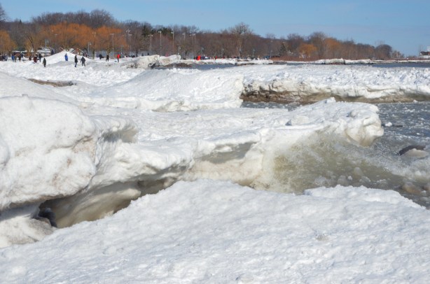 snow and ice accumulations along the shore of Lake Ontario, waves crashing into the shore