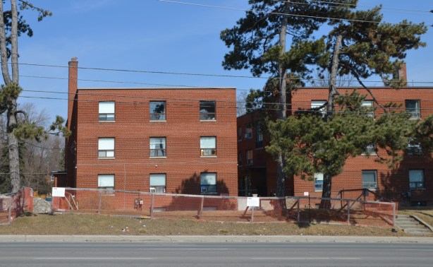 two 3 storey red brick apartment buildings 