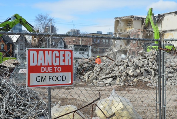 red and white sign, danger due to signs, on a chainlink fence at a construction site in Regent Park, danger due to GM food (genetically modified food)