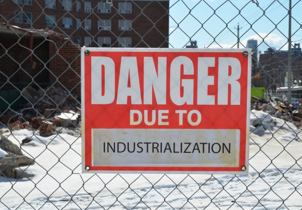red and white sign, danger due to signs, on a chainlink fence at a construction site in Regent Park, danger due to industrialization