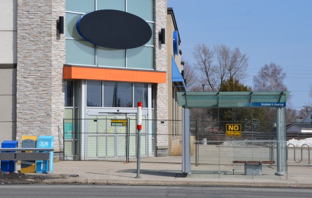 empty building, with fence around it and no trespassing signs 
