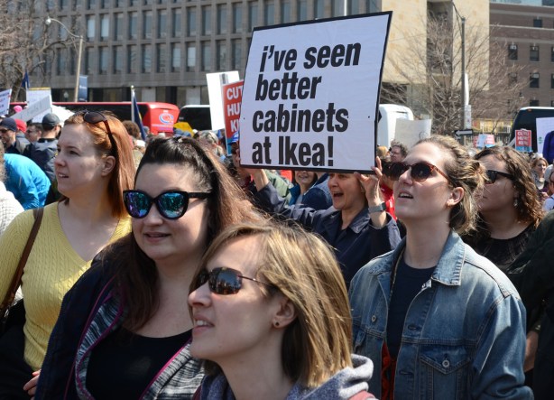 person holding a placard protesting Doug Fords proposed cuts to education funding, I've seen better cabinets at IKEA