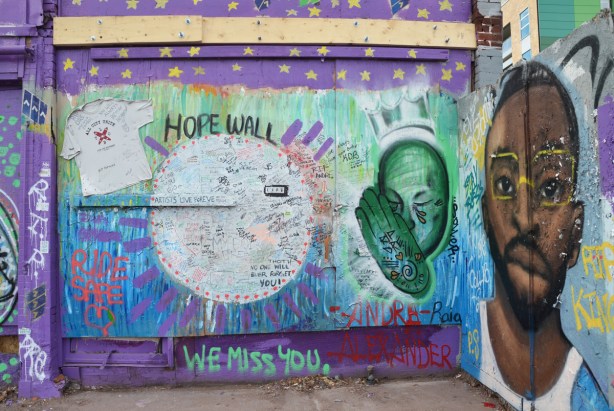 wall, plywood hoardings, covered with paint and graffiti as a Hope Wall, in memory of Andre Alexander who was killed when hit by a car. painting of his face, plus large space for people to write messages, on Spadina near Kensington Market, 