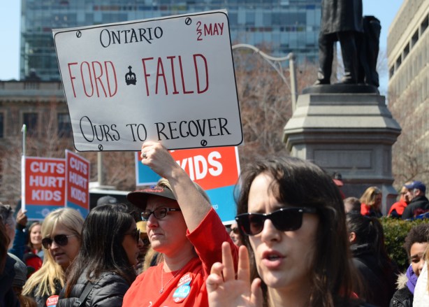 person holding a placard protesting Doug Fords proposed cuts to education funding, 