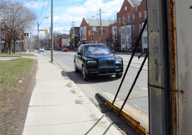 new rolls royce parked on the side of a street after being unloaded from a truck 