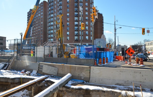 red brick apartment buildings with crosstown LRT construction in front of them. 