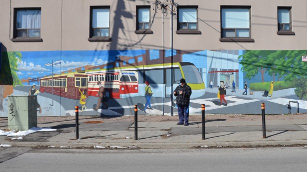 mural of the evolution of TTC streetcars and LRT vehicles, painted by Jim Bravo in 2017, stylized but realistic looking 