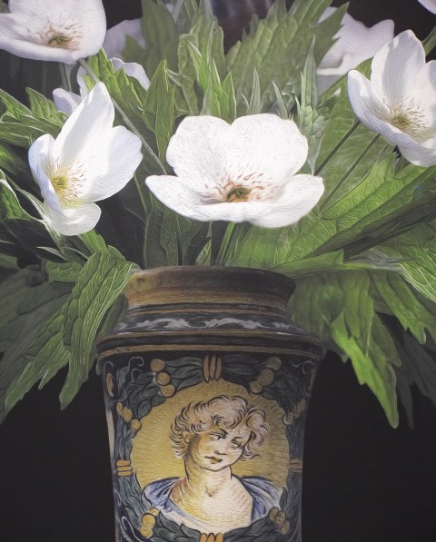 white flowers and greenery in a vase with a picture of a young man on it, part of a larger photograph by T.M. Glass in a gallery