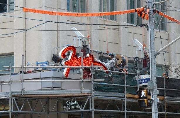 scaffolding around the building with an orange Frans sign on it - Frans restaurant at Shuter and Victoria streets 