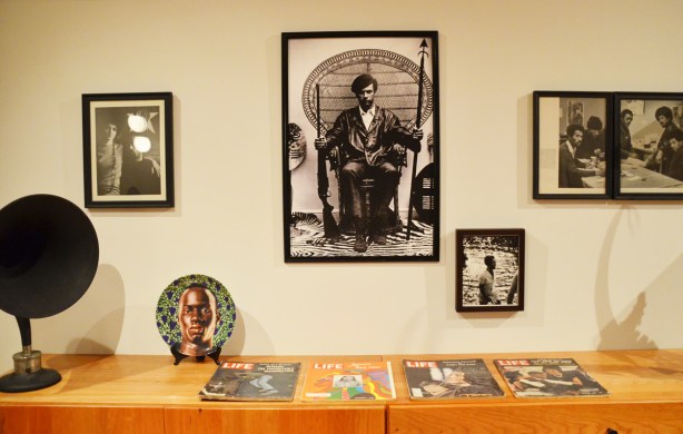 a collection of pictures on the wall and Life magazines on a table, part of Heave, an exhibit by Carrie Mae Weems at University of Toronto art museum and gallery 
