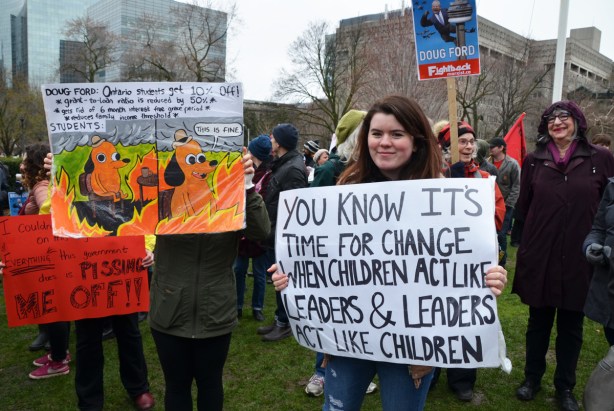 a few people with home made placards at an anti-Ford May day protest