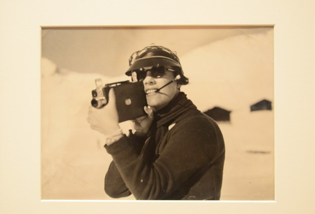 old sepia tone photo of a person with an old fashioned movie camera