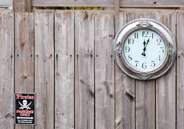 a clock and a sign attached to a wall. 