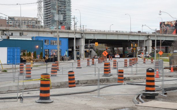 many orange and black cones on a stretch of road that is having work done on it 