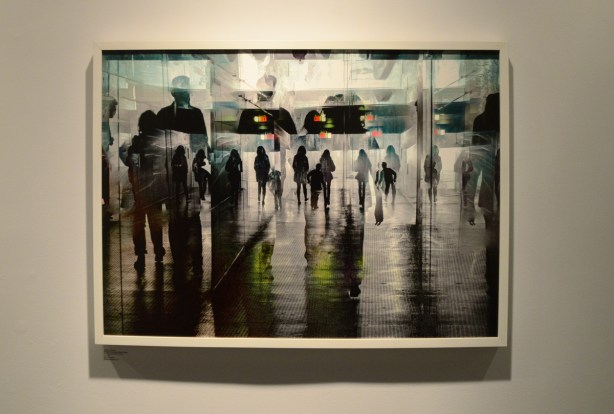 a photo of a large entrance way, lots of glass, and many people superimposed over each other.