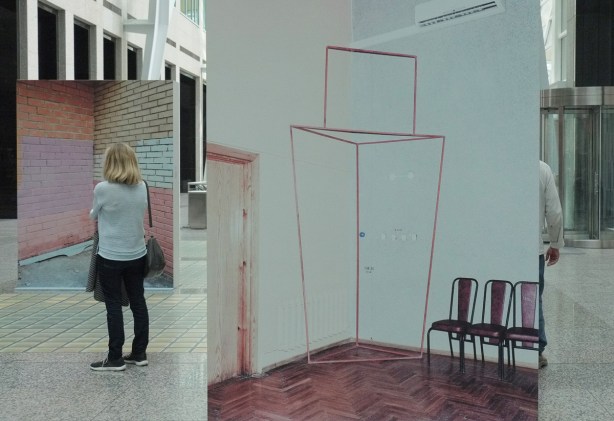 two large photos on exhibit, with a woman standing in front of one of them. 