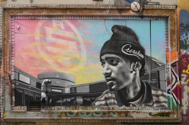 black and white mural portrait of a young man in a toque, signed sum artist