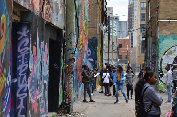 teacher, students, and other people in graffiti alley