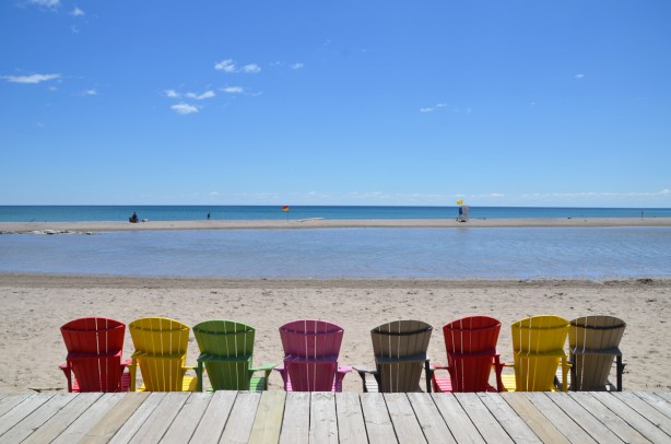 a line of muskoka chairs along the edge of the boardwalk, beach, Lake Ontario 