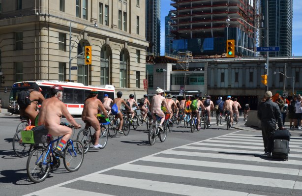 world naked bike ride goes down Bay street, south of Front, a large group of naked people on bicycles
