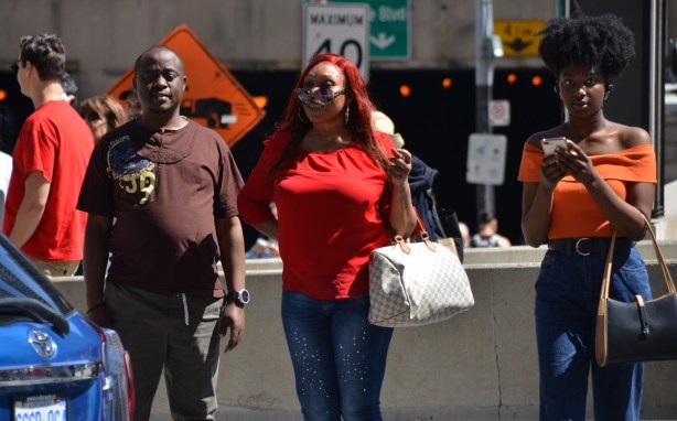 world naked bike ride - 3 people watching them, not sure of what to think of naked bike riders