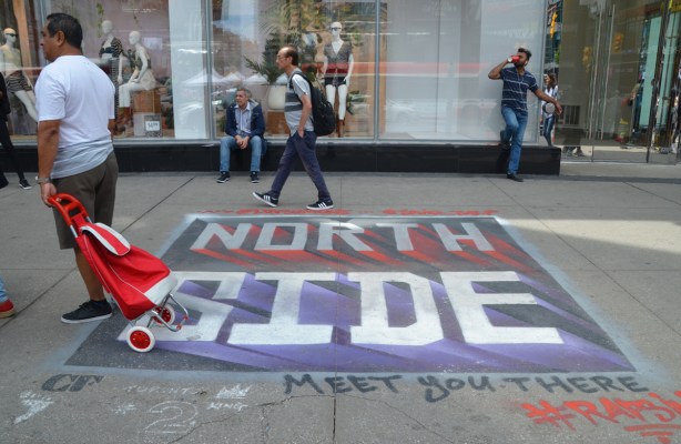 painted on a sidewalk in front of the Eaton Centre, are words North Side, written in Raptors colours, as support for Toronto's basketball team as they play on NBA finals playoffs 
