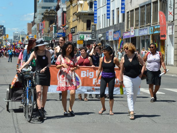 NDP group in dyke march, with orange banner and several women