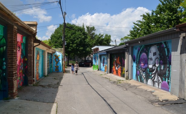a mother and daughter walking down an alley