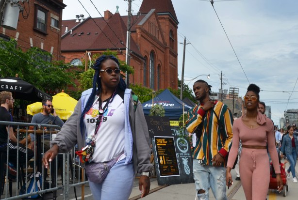 people on the street at Taste of Little Italy, passing by a bar with a large patio 