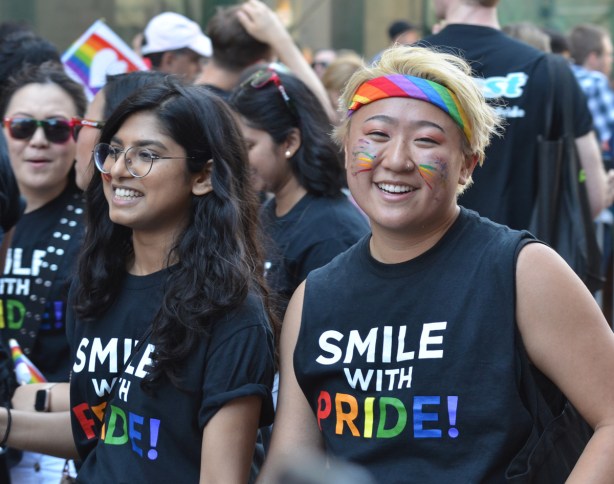 two people with T shirts that say smile with pride 