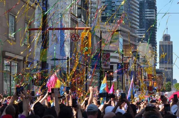 thousands of pieces of mylar in the air, just released over the heads of people watching the pride parade 