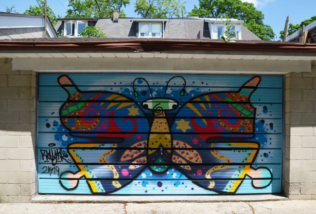 stylized butterfly with lots of colours and spots, on a garage door 
