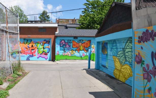 three butterfly murals on three garage doors in an alley