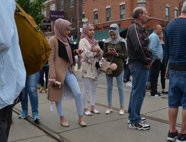 three muslim women in head scarves on the street, street festival 