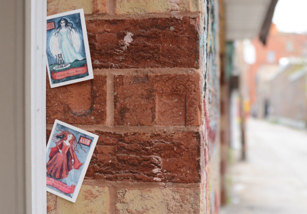 two cars stuck into the crack formed between a door and a wall, two witch cards, 