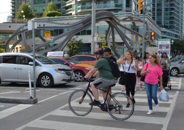 cars, cyclists, and pedestrians at an intersection
