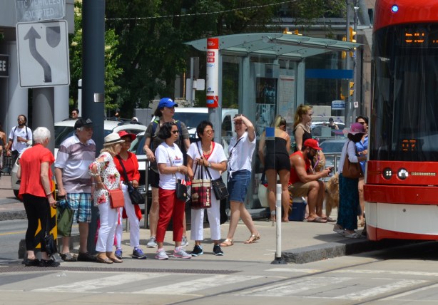 a crowd of people at a TTC stop on Queens Quay 