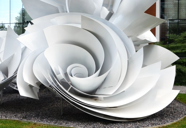 part of a large sculpture, sheets of white material curve and join together like the shape of a rose