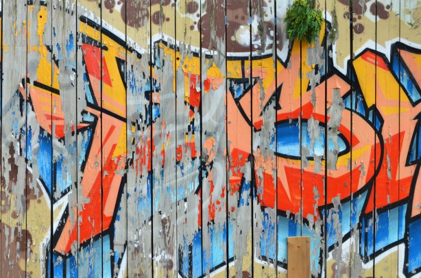 paint peeling off wood fence, street art painting only partilly still there 