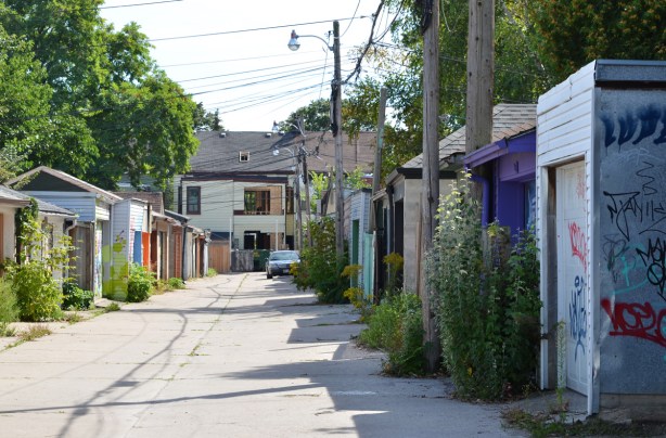 looking down a short alley, Albert Jackson Lane, with garages lining both sides, the backs of houses at the end including one that is being renovated