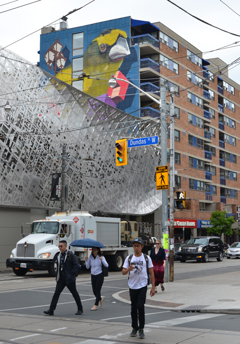 the corner of Dundas and McCaul with a large mural by birdo looking over it 