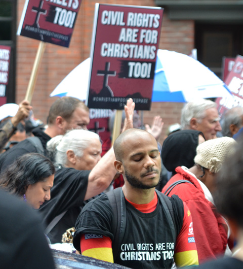 a man with his eyes closed, during a protest 