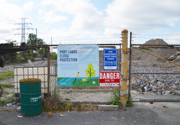 fence with signs, danger due to sign, plus sign that says Port Lands Flood Protection